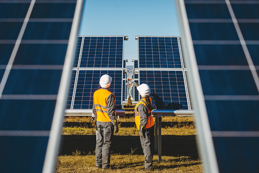 2 workers in hi vis looking at solar panels