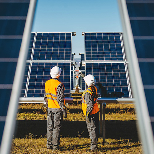 2 workers in hi vis looking at solar panels